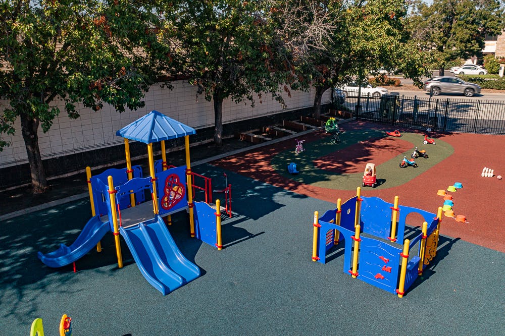Empty playground with blue and yellow play structures and slides