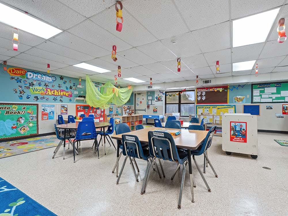 Classroom with tables, blue chairs, and decorations on the walls and ceiling