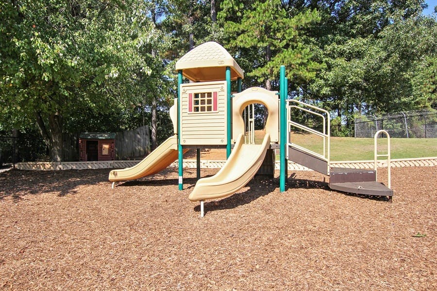 Playground structure with slides and steps on wood chips