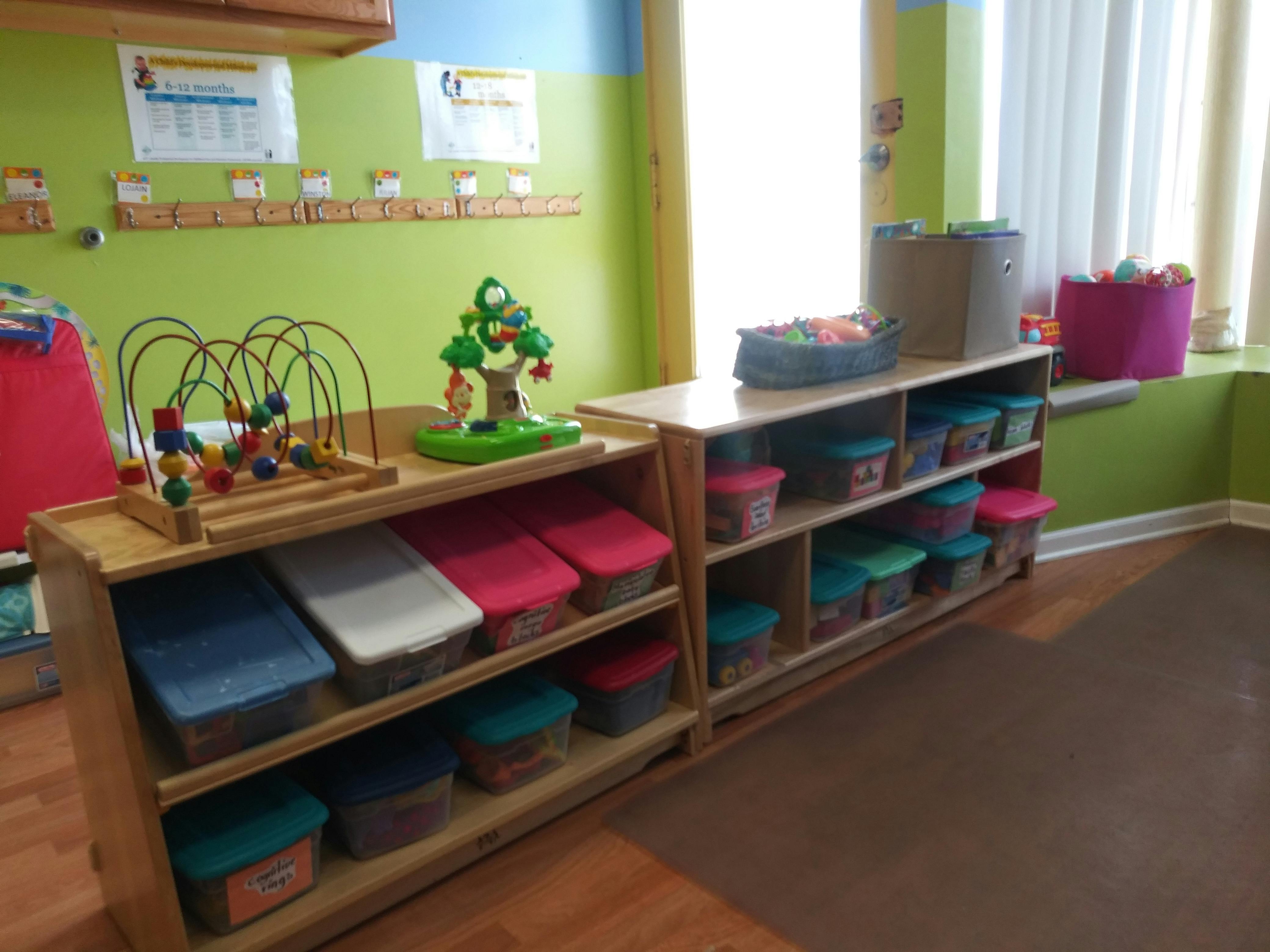Classroom with wooden shelves filled with colorful bins and toys