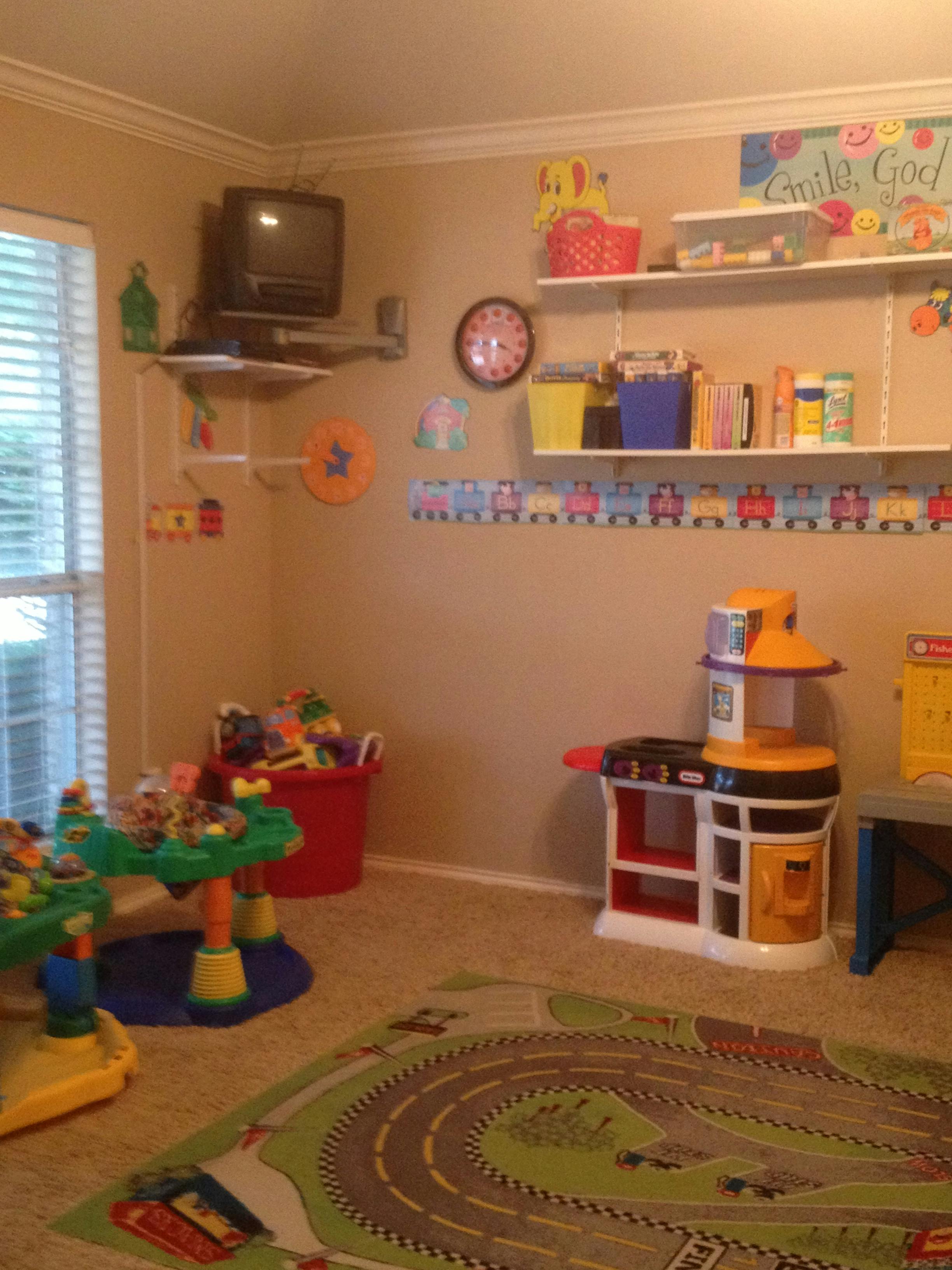 Playroom with toys, shelves, and a road-themed rug