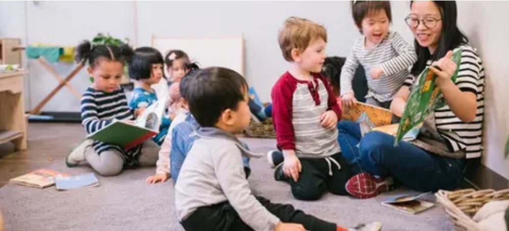 Adult reading to children in a classroom