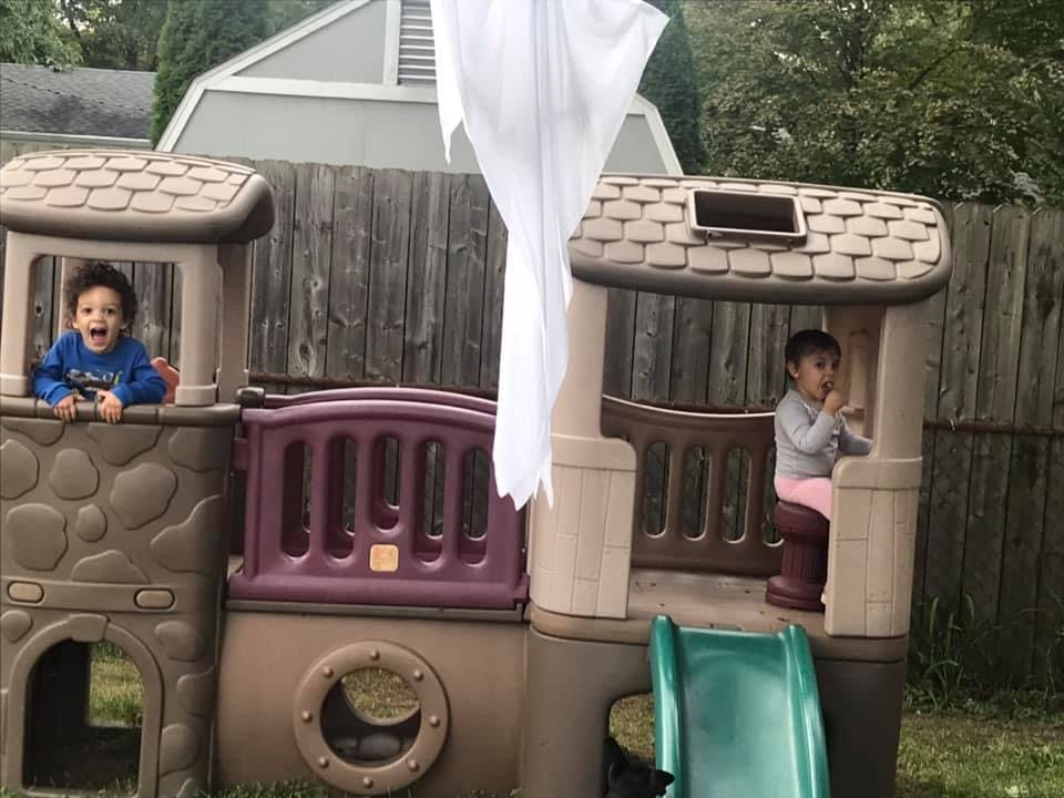Two children playing on an outdoor playset