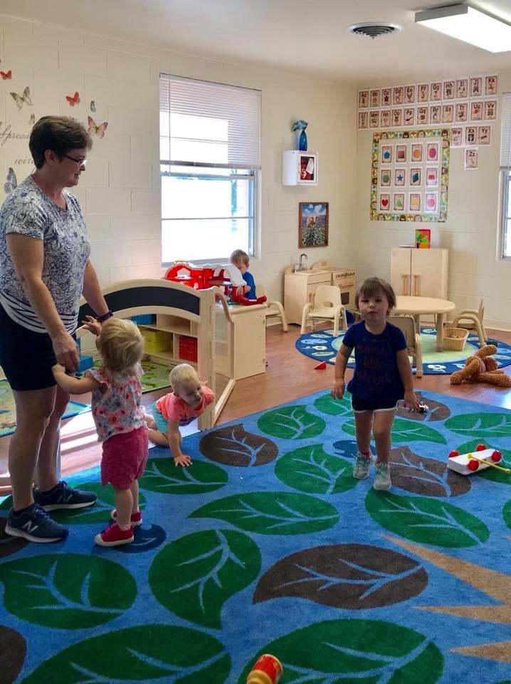 Adult and three children in a classroom