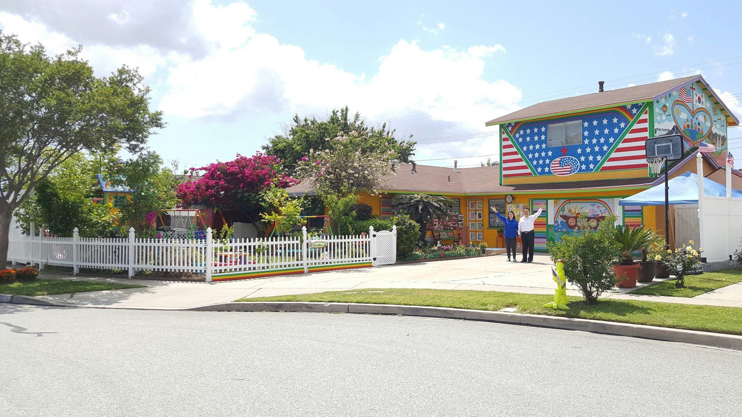 House with American flag mural and two people standing in front