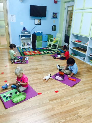 Children playing on mats in a classroom