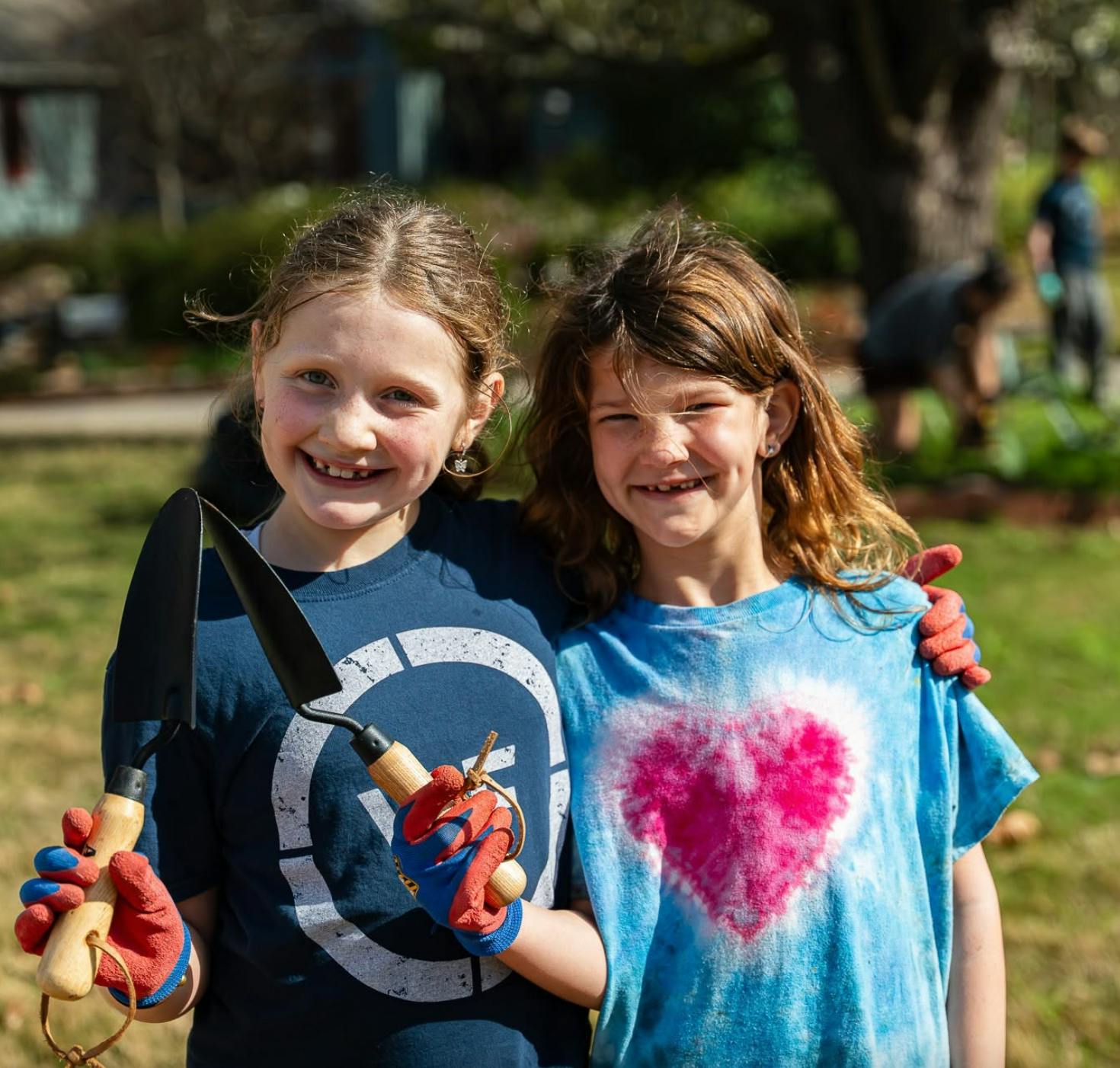 Two children holding garden trowels