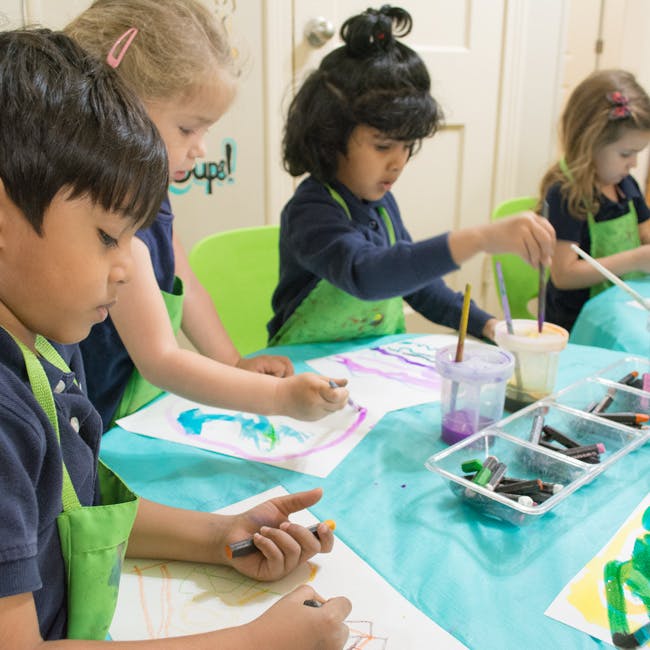 Children drawing and painting at a table