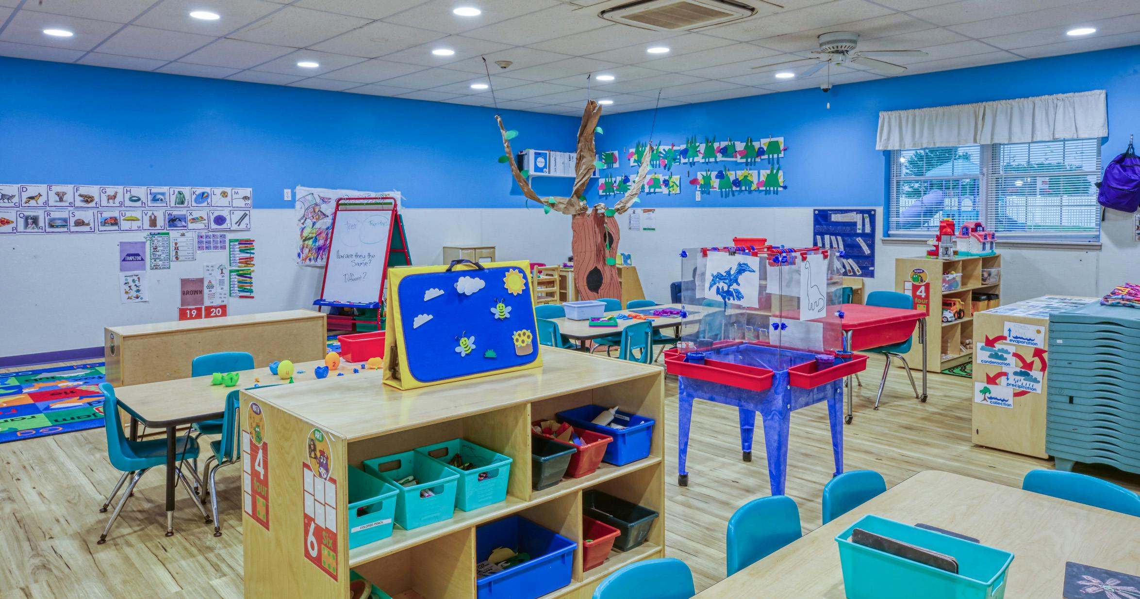 Colorful classroom with small tables, chairs, and learning materials