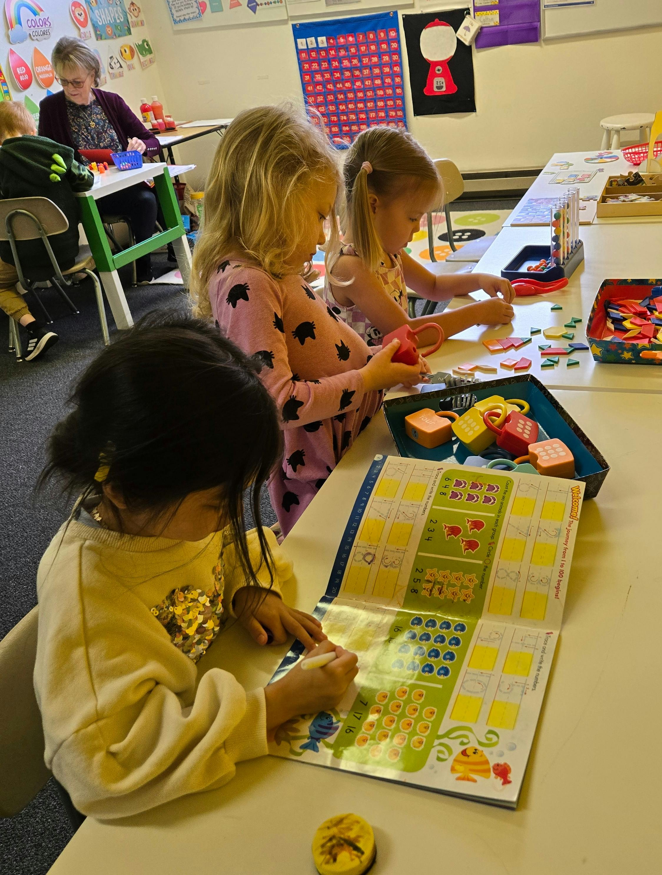 Children playing with toys and books in a classroom