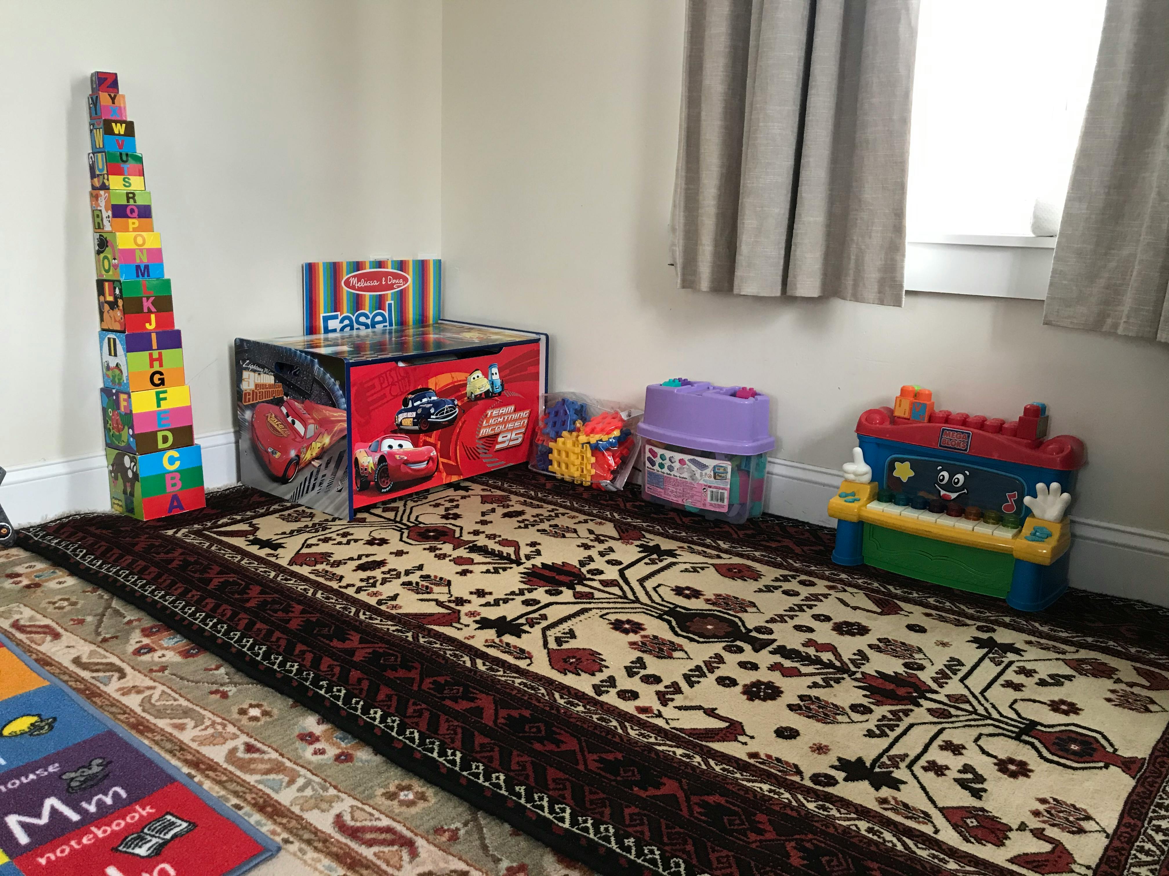 Children's toys in a room with a patterned rug