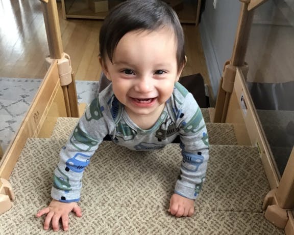Child crawling up carpeted stairs