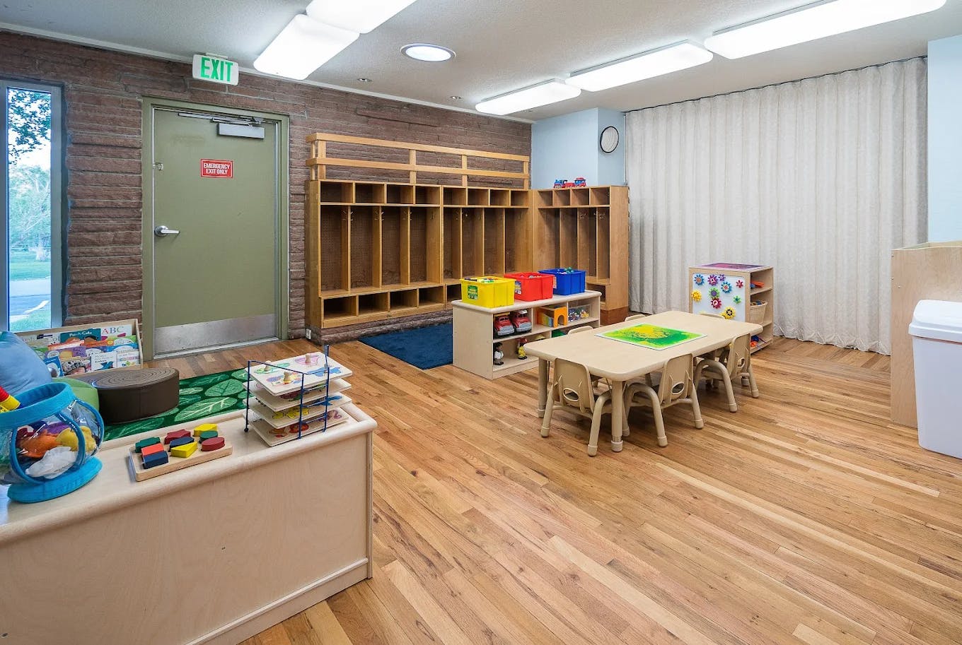 Classroom interior with small tables, chairs, and storage units for children