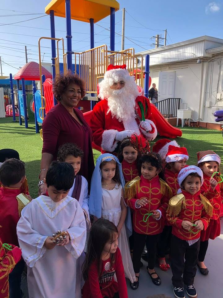 Person dressed as Santa Claus with a group of children in costumes