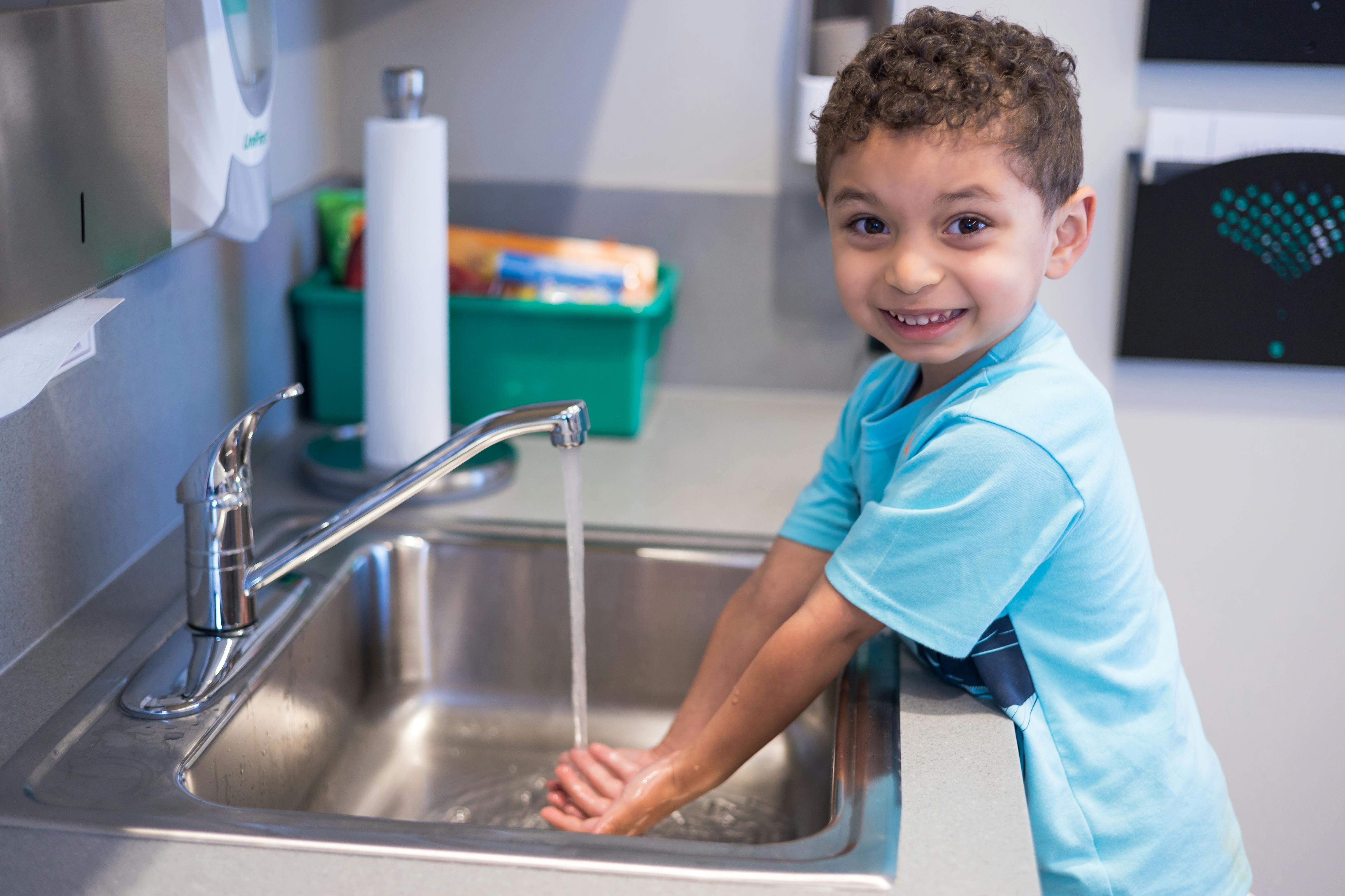 Child washing hands at a sink