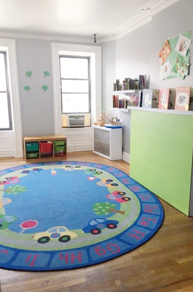 Playroom with a blue circular rug featuring cars and trees
