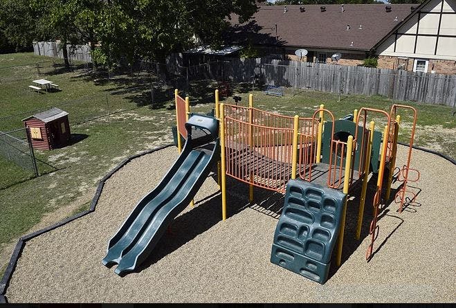 Playground with slides, climbing wall, and sand base