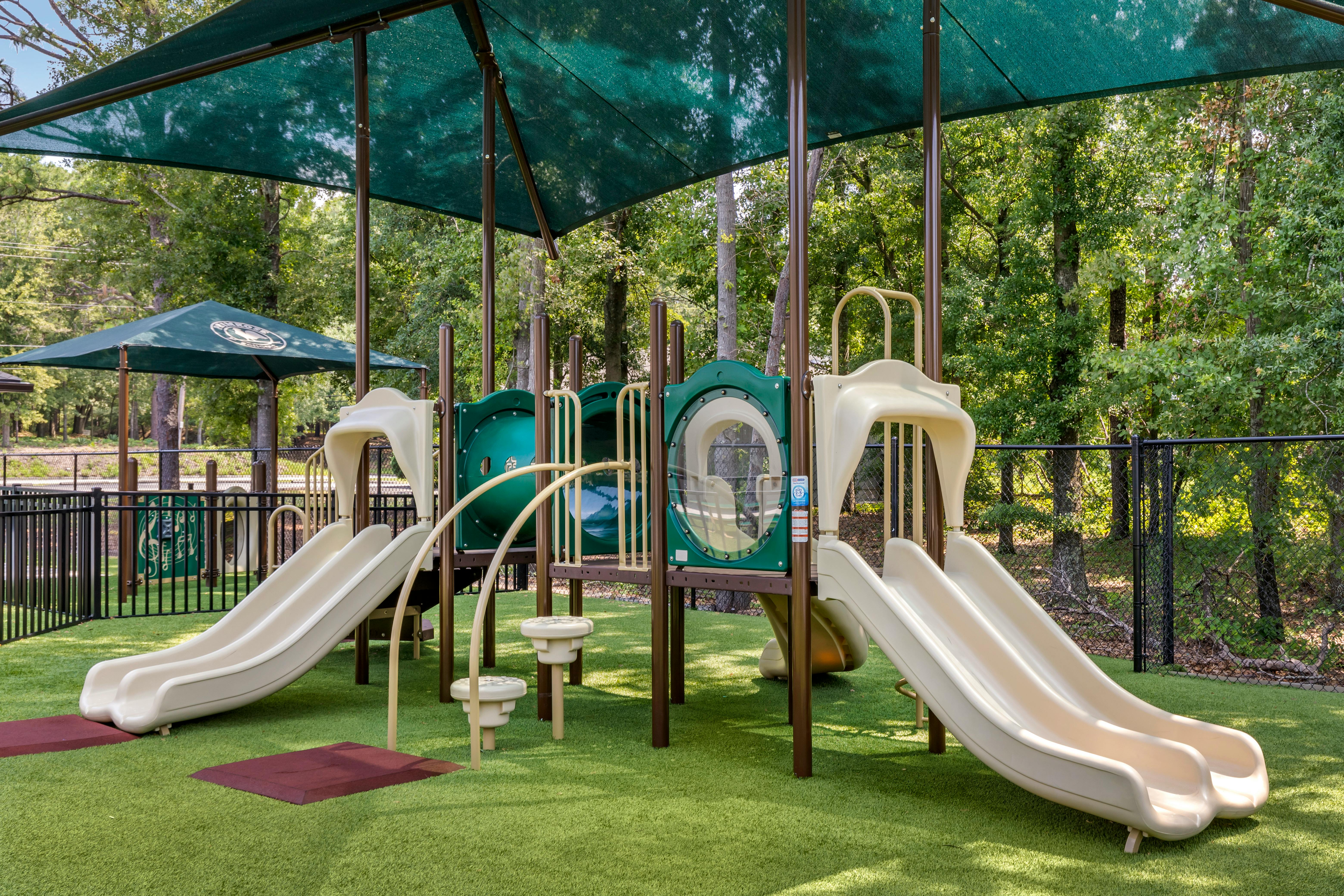 A playground with two slides and climbing structures