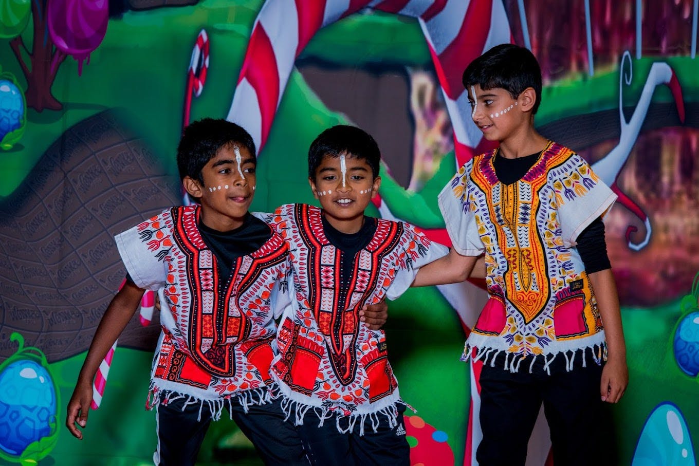 Three children in patterned shirts with face paint