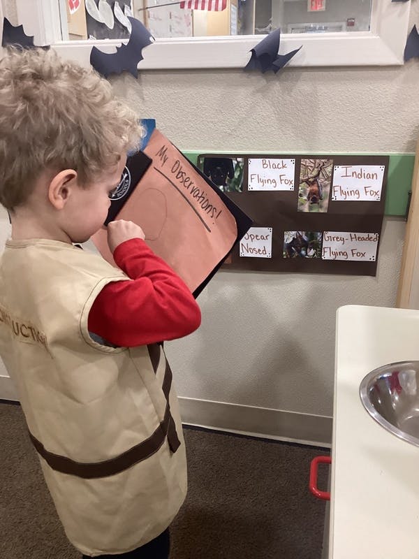 Child holding a clipboard with "My Observations" written on it