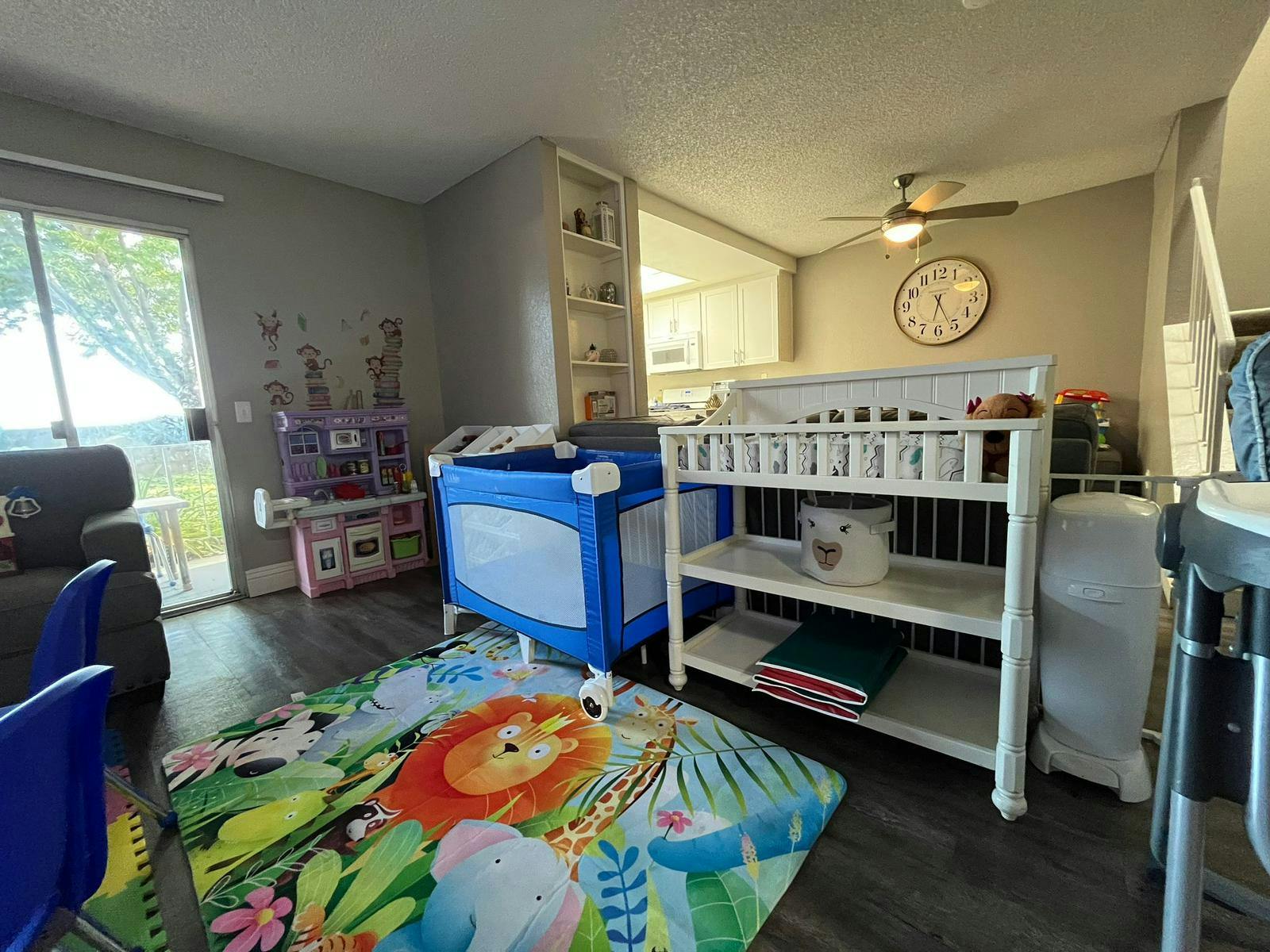 Playpen and changing table in a room with a colorful playmat