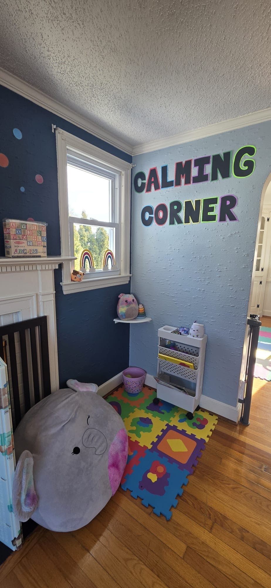 Children's room with a window, toys, and the words CALMING CORNER on the wall