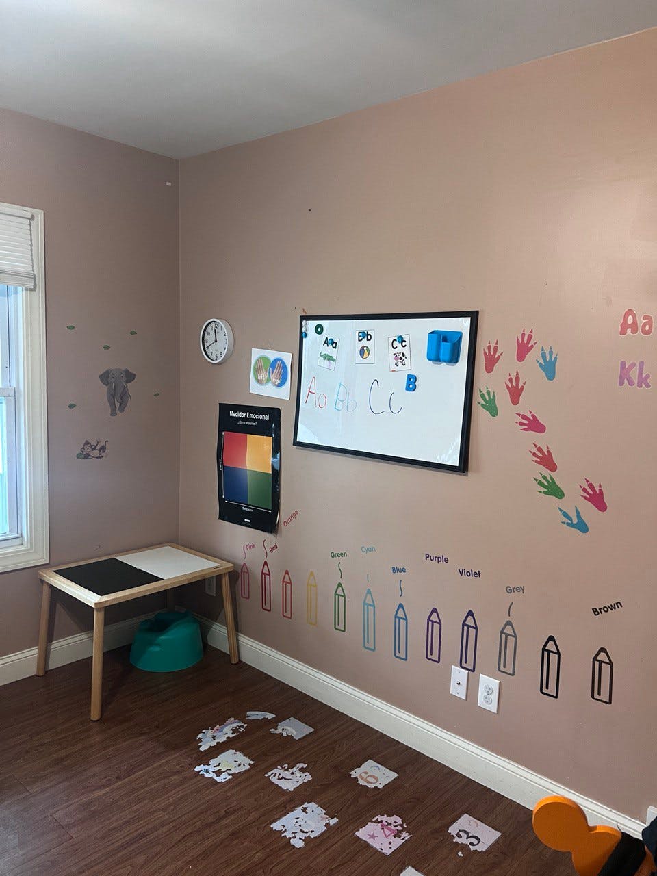 Playroom with a small table, whiteboard, and wall decorations