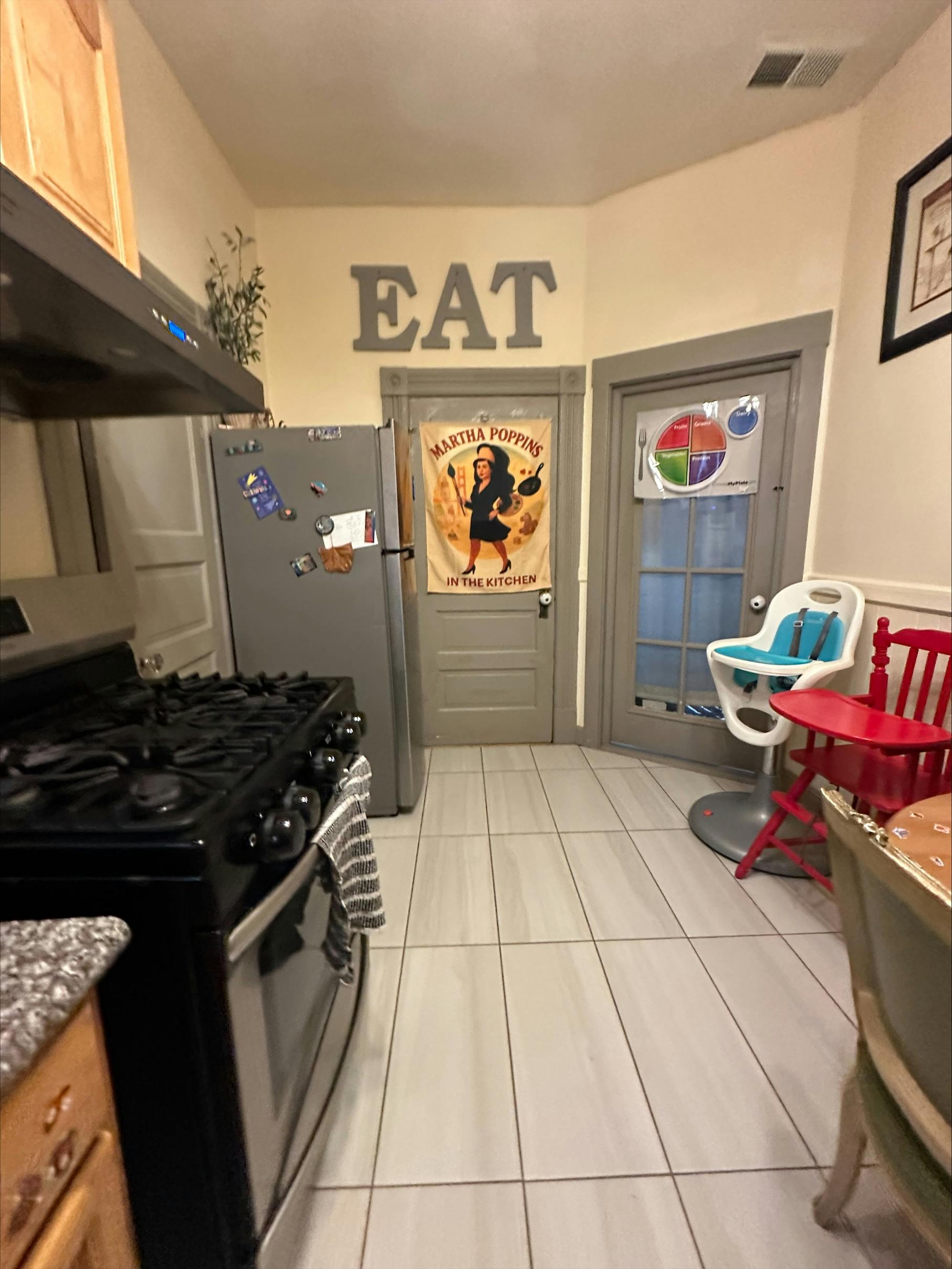 Kitchen with a stove, refrigerator, and a sign that says EAT