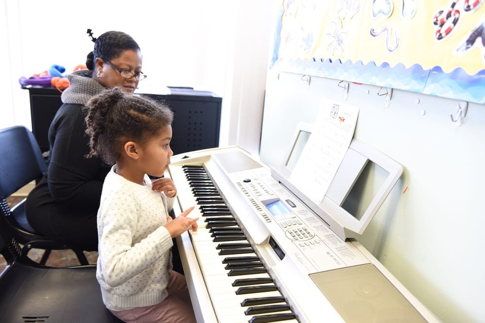 Person and child playing a keyboard