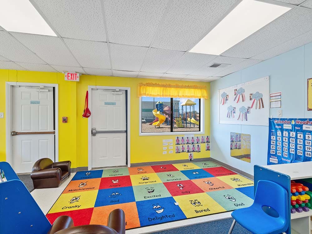 Colorful classroom with an alphabet rug and a view of a playground