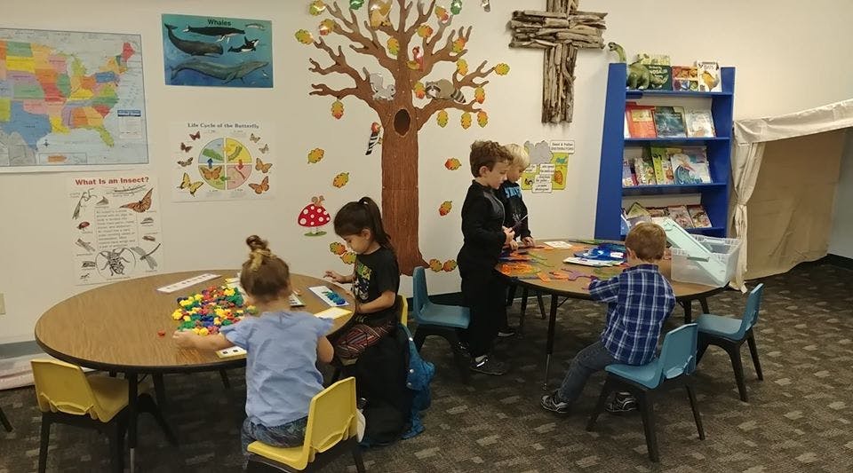Children playing at tables in a room