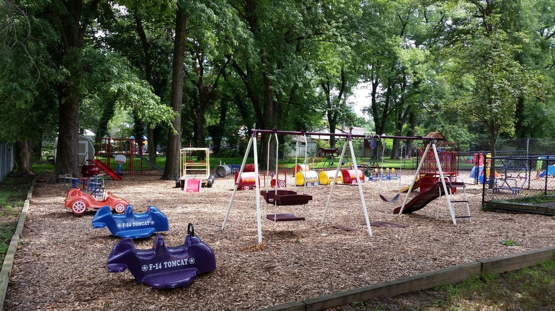 Playground with swings, slides, and spring riders on wood chips