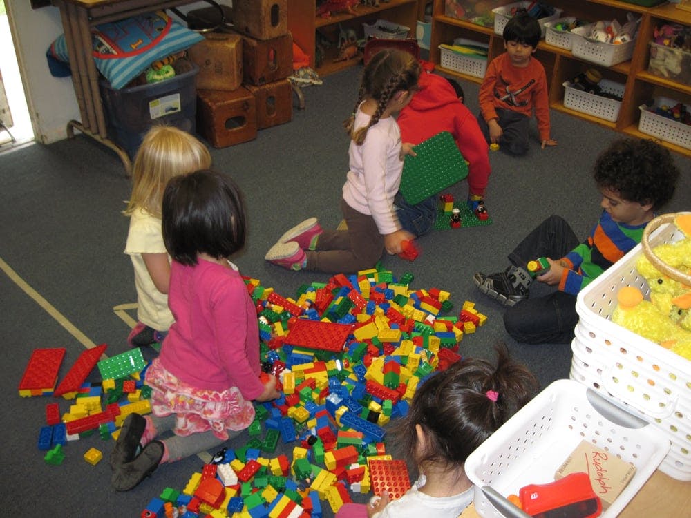 Children playing with colorful building blocks on the floor