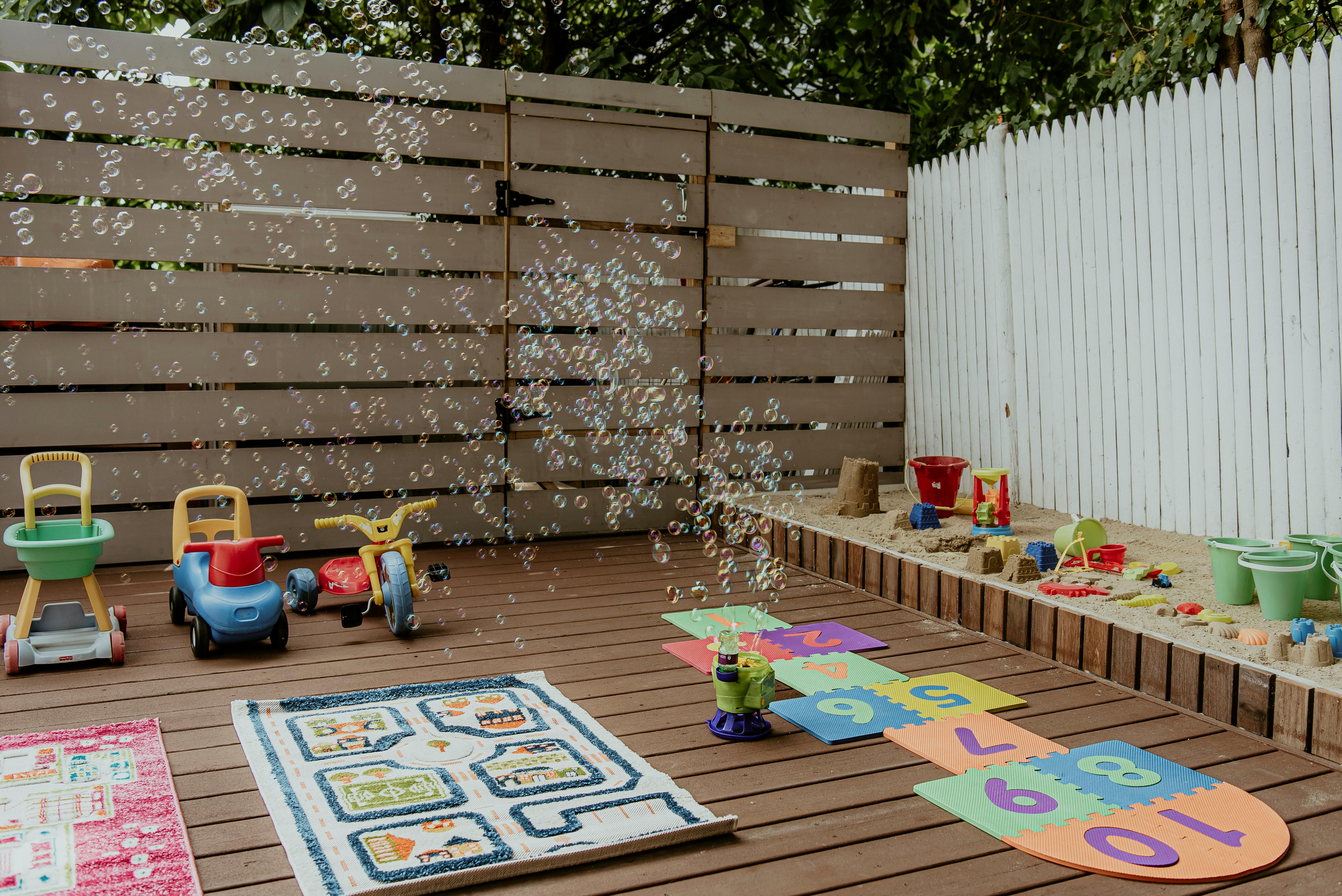 Outdoor play area with toys, rugs, and bubbles