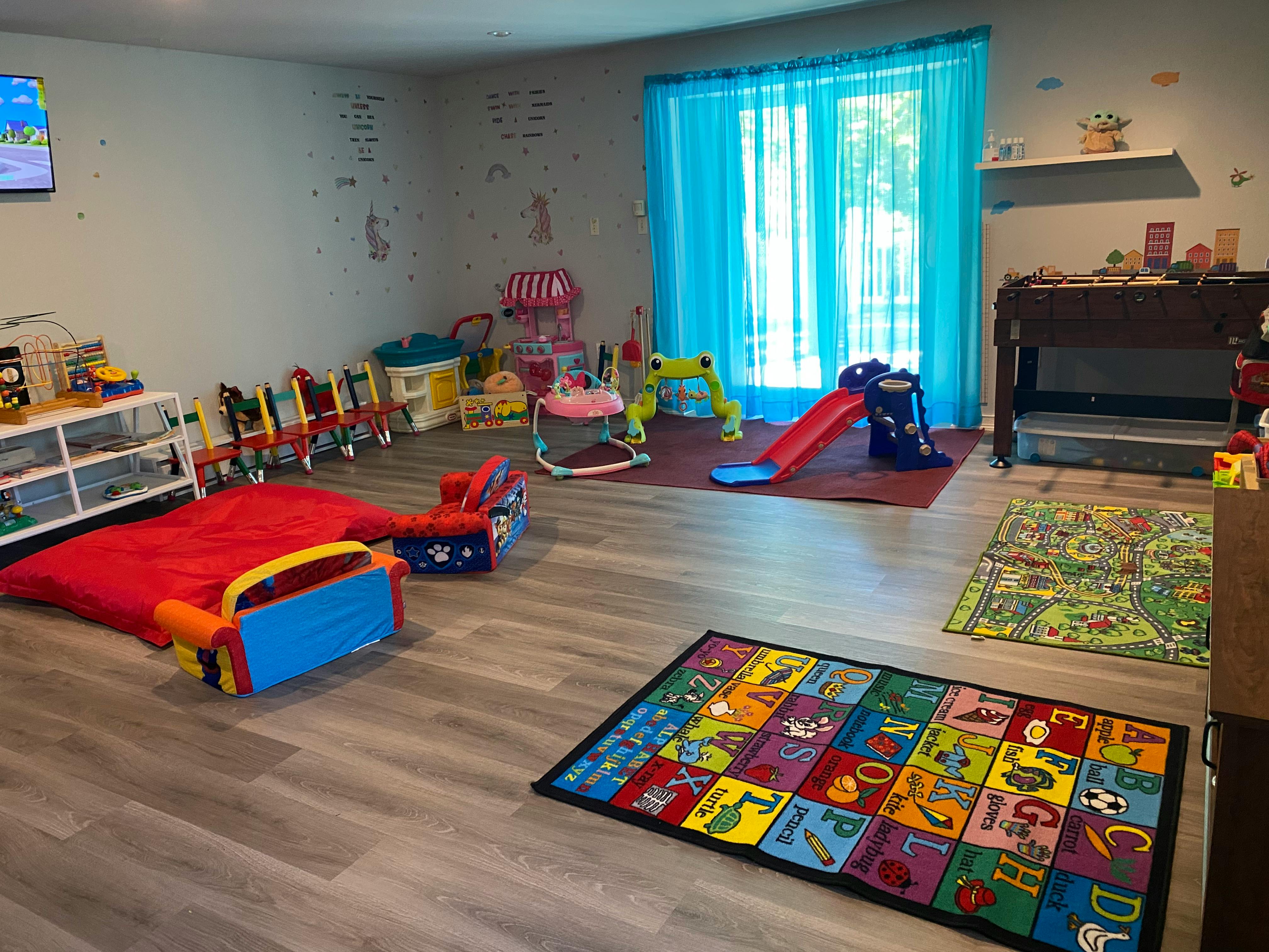 Playroom with various toys, a red slide, and colorful rugs