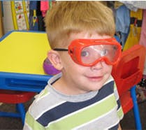 Child wearing red safety goggles