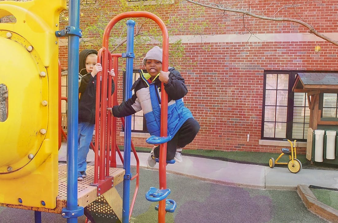 Two children on a playground climbing structure