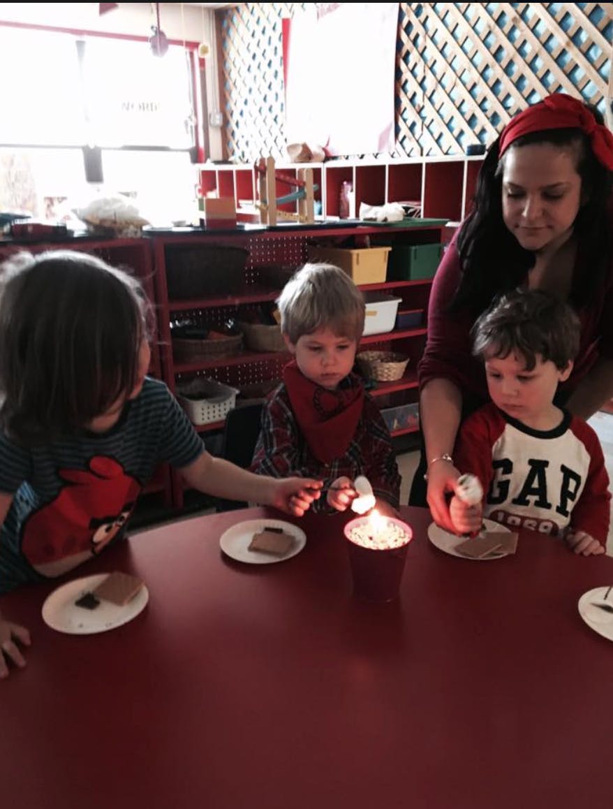 Adult and three children at a table with plates and candles