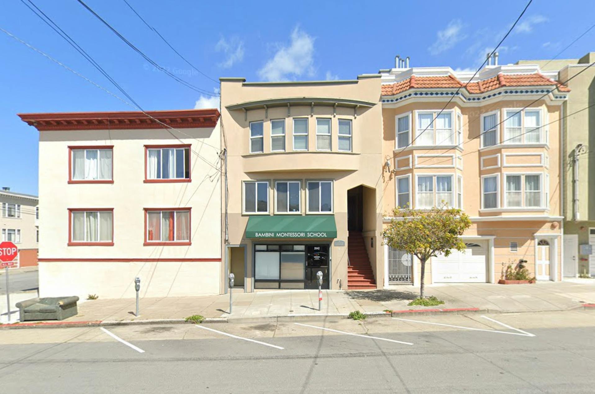 Row of multi-story buildings with a street and parked cars in front