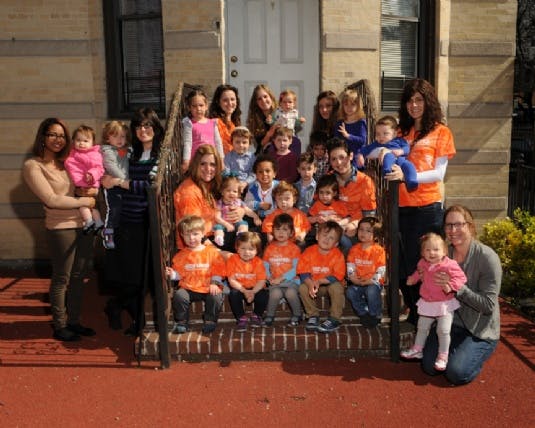Group of adults and children posing on steps