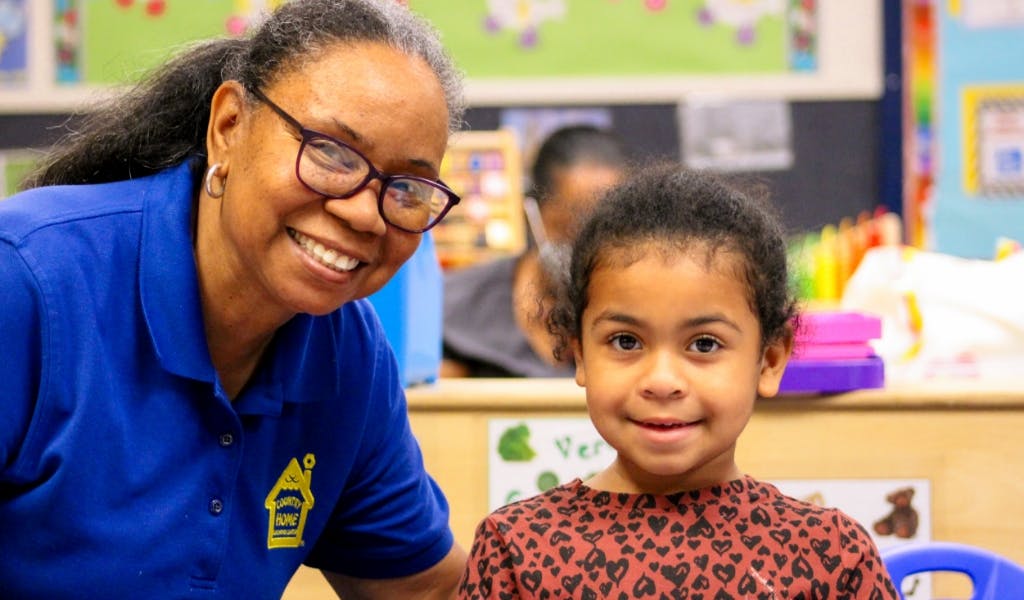 Adult and child smiling in a classroom