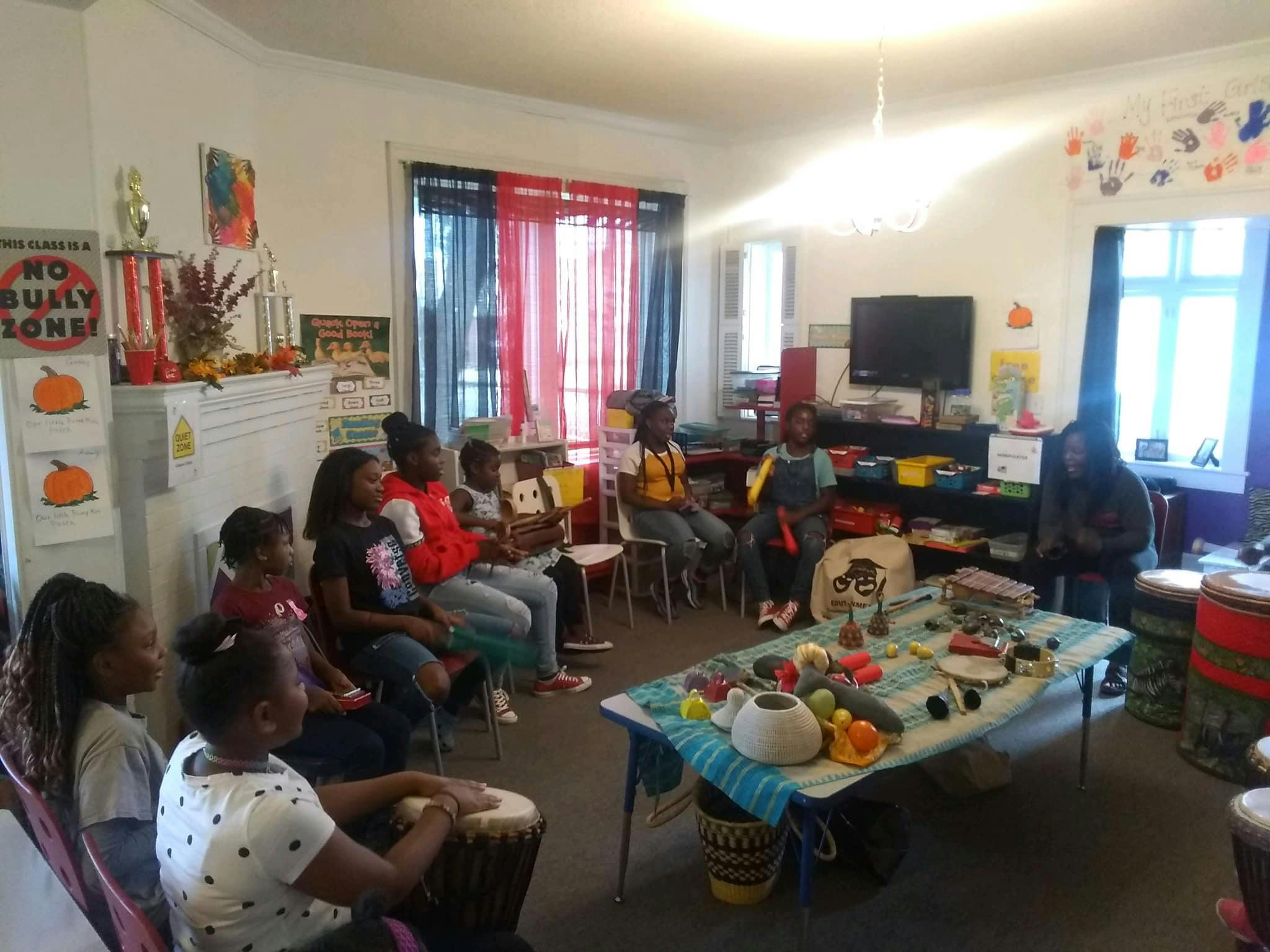 Group of people gathered in a room, some seated, some standing