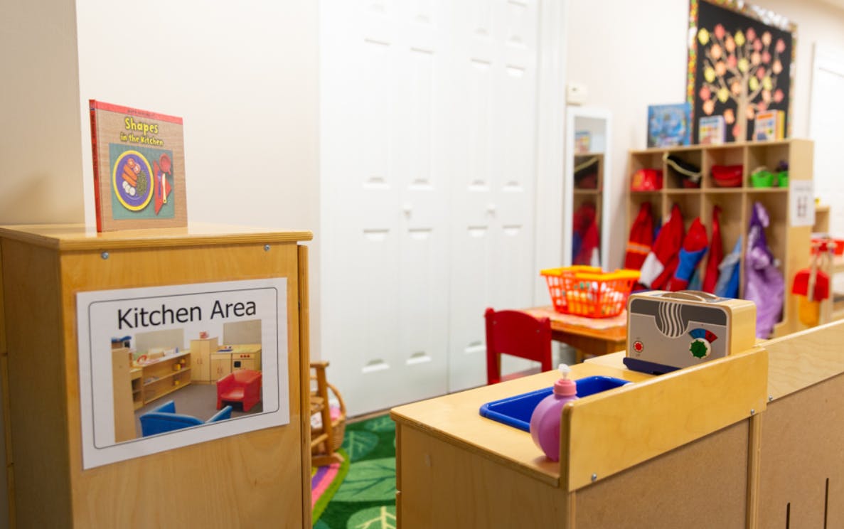Play kitchen area in a classroom with a sign that reads "Kitchen Area"