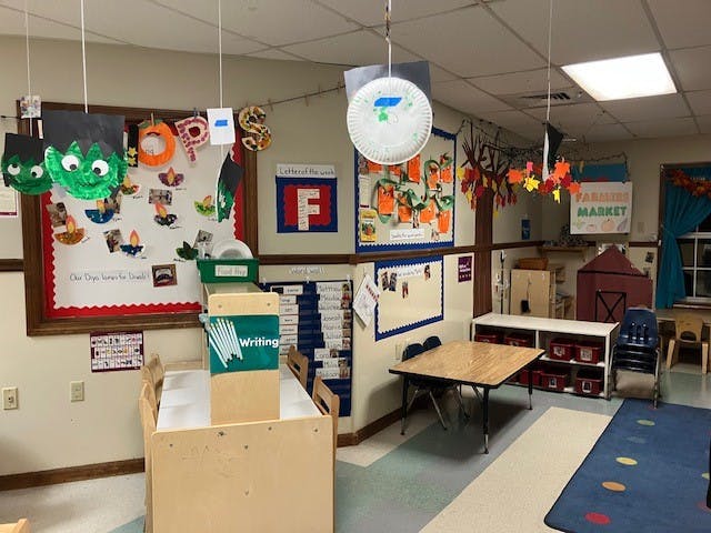 children's classroom with decorated bulletin boards and small tables