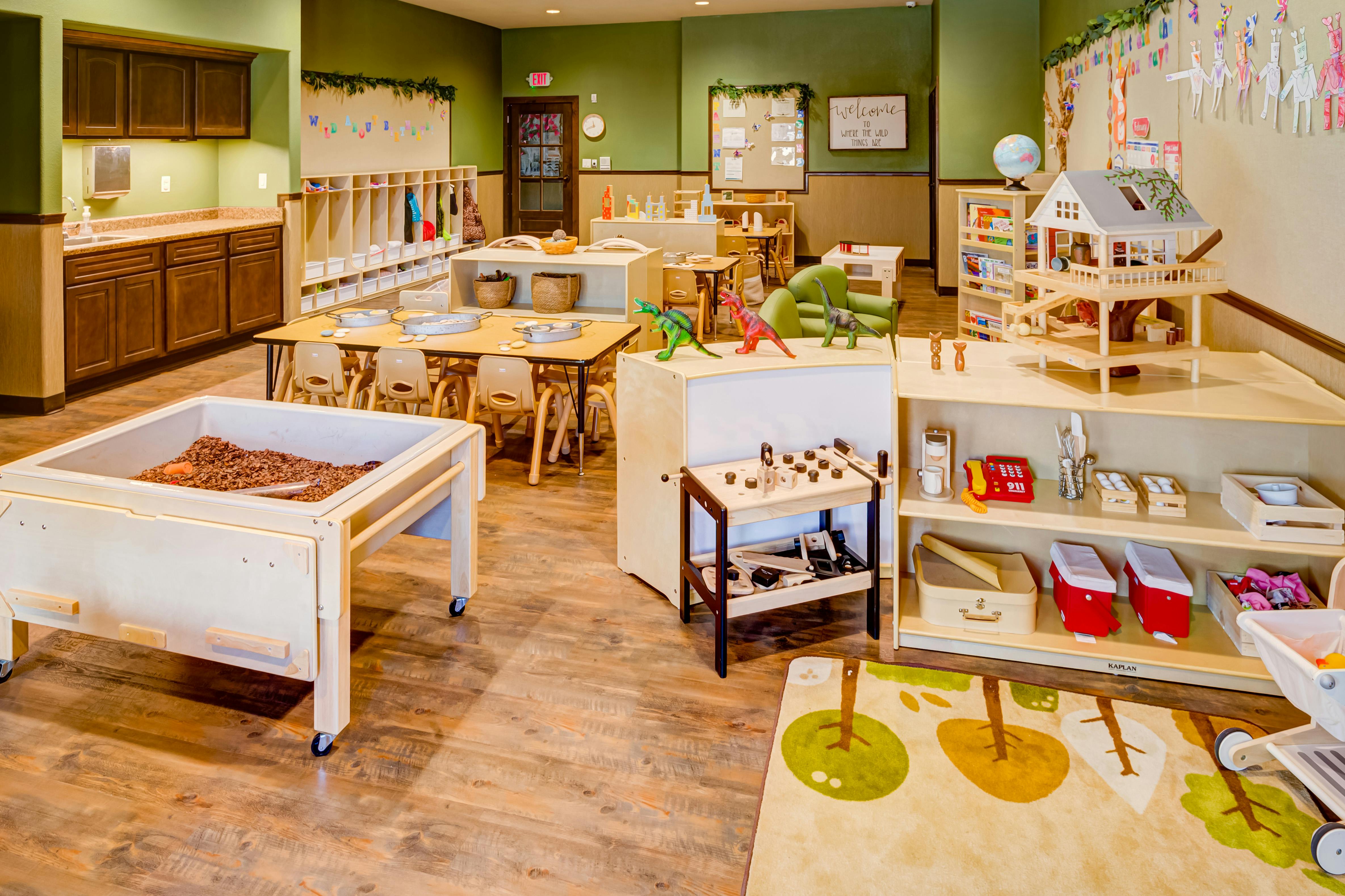 Classroom with various play areas and wooden furniture