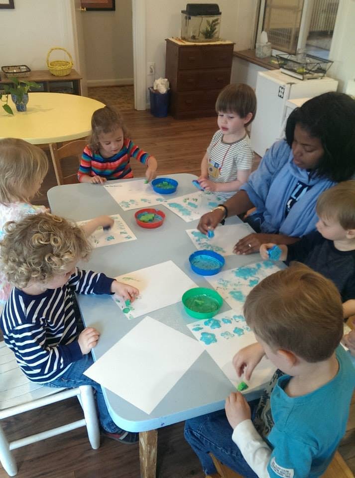 Adult and children doing art at a table