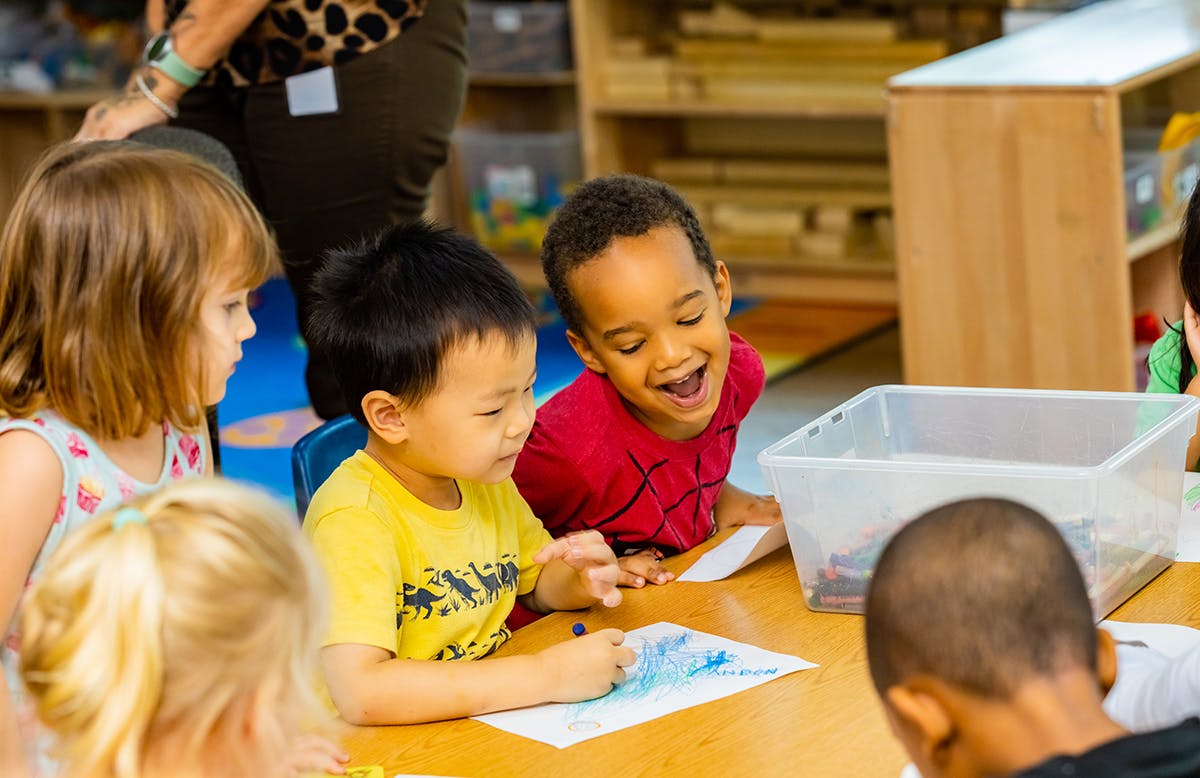 Children drawing at a table in a classroom