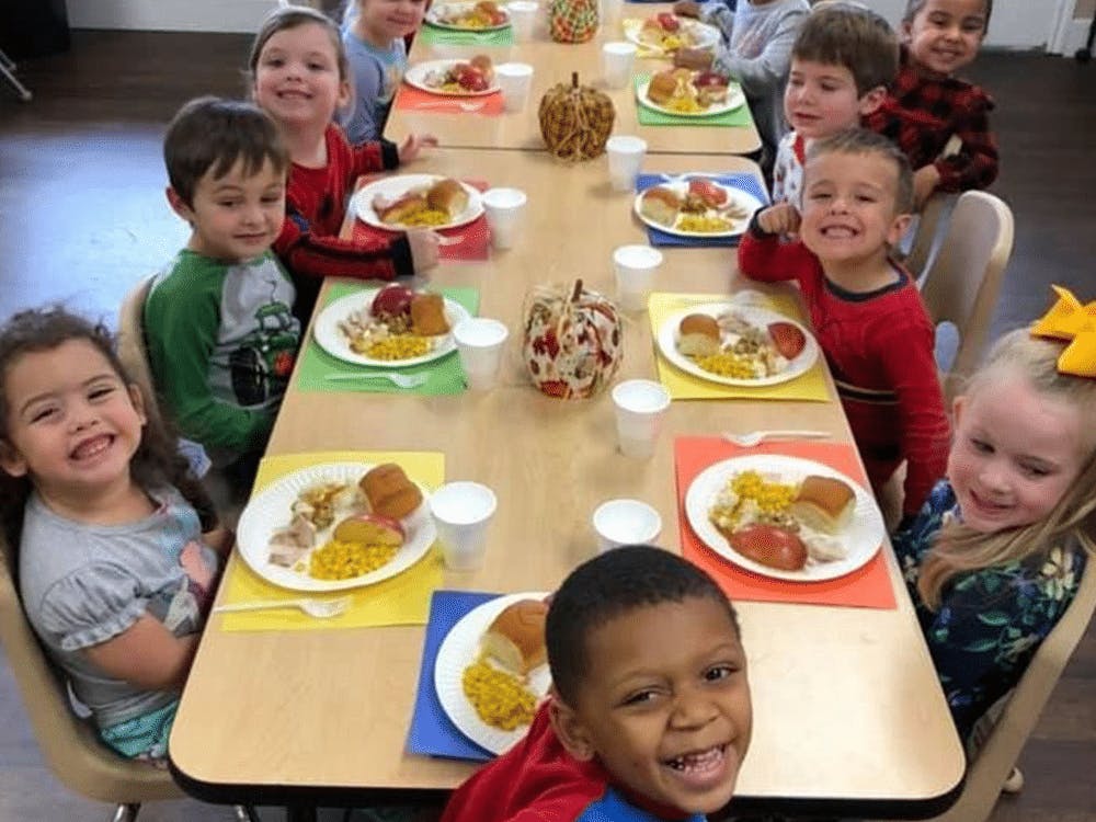 Children sitting at a table with plates of food