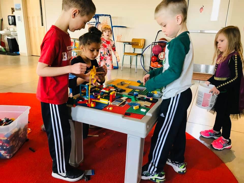 Children playing with building blocks at a table