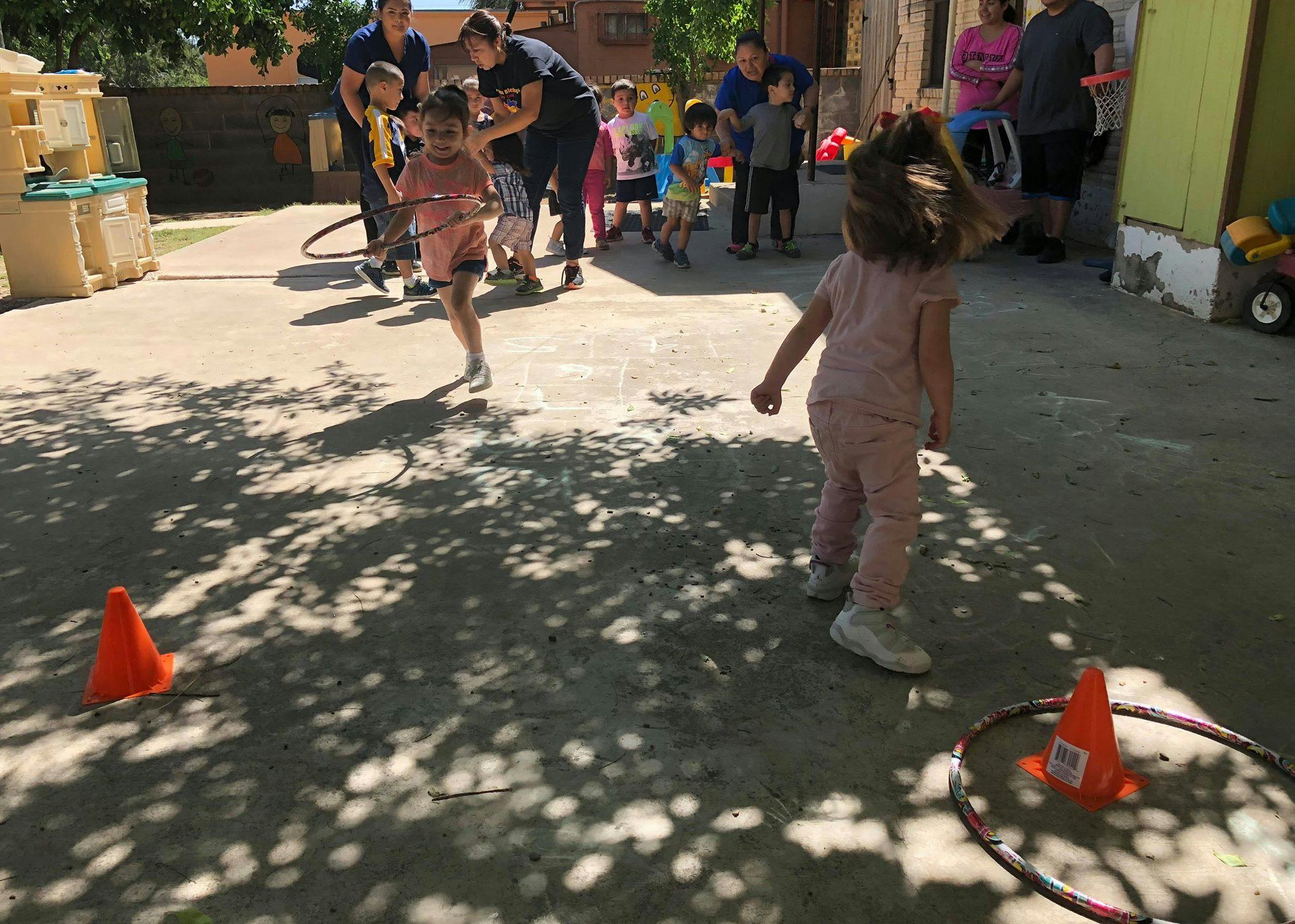 Children and adults playing outdoors with orange cones